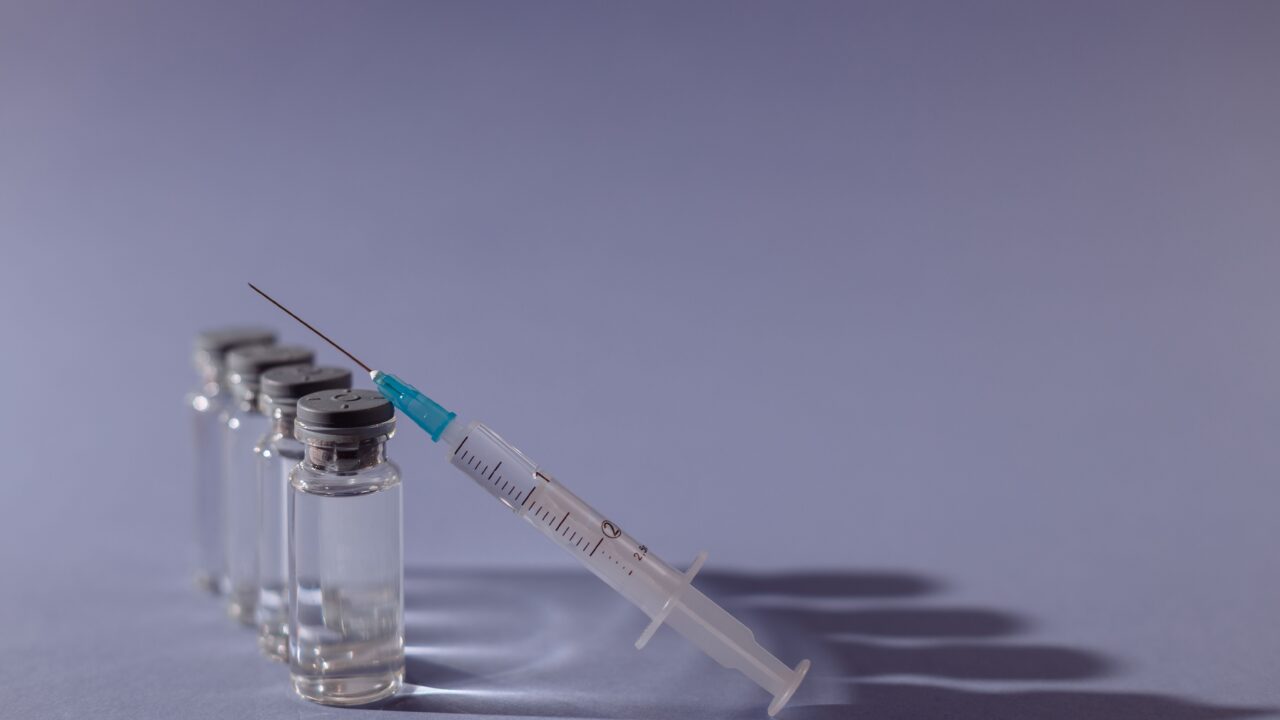 Флаконы с вакциной и шприц — вакцинация против кори